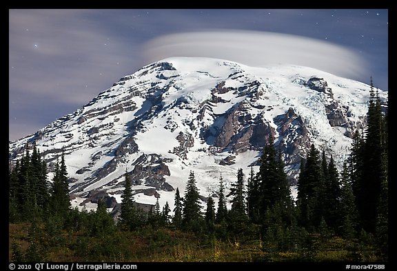 Mount Rainier capped by lenticular cloud, night. Mount Rainier National Park, Washington, USA.