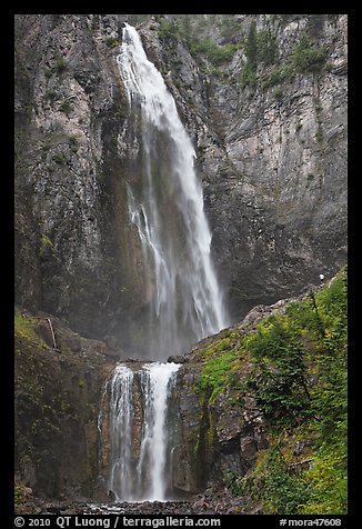 Hiker in the distance gives scale to Comet Falls. Mount Rainier National Park, Washington, USA.