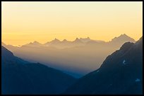 First sunrays lighting peaks above Cascade Pass, North Cascades National Park. Washington, USA.