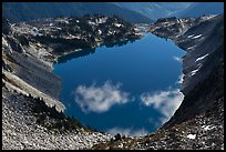 Fluffy clouds reflected in blue lake, North Cascades National Park. Washington, USA.