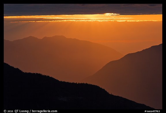 Layered ridges with sun behind clouds, North Cascades National Park.  (color)