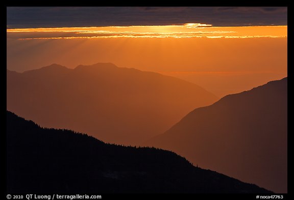 Layered ridges with sun behind clouds, North Cascades National Park. Washington, USA.