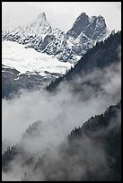 Inspiration Peak and the Pyramid rising above clouds, North Cascades National Park. Washington, USA.