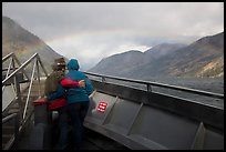 Couple at bow of boat looking at rainbow over Lake Chelan, North Cascades National Park Service Complex. Washington, USA.