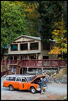 Man fixing old car in front of North Cascades Lodge, Stehekin, North Cascades National Park Service Complex. Washington, USA.