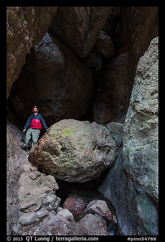 Man with headlamp looking up in Balconies Cave. Pinnacles National Park, California, USA.