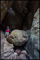 Man with headlamp looking up in Balconies Cave. Pinnacles National Park, California, USA.