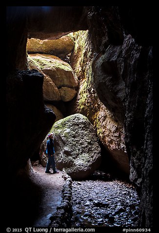 Hiker looking around Bear Gulch Cave. Pinnacles National Park (color)