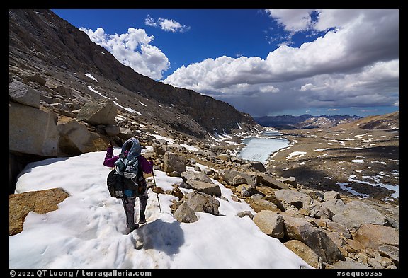 Backpacker crossing snowy section of the John Muir Trail below Forester Pass, Sequoia National Park. California