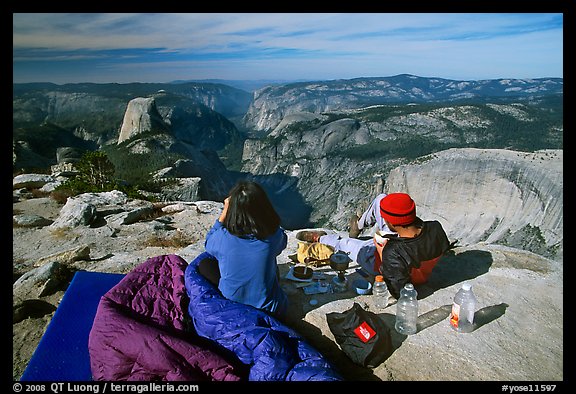 Backpackers eat breakfast, looking at Yosemite Valley from Clouds Rest. Yosemite National Park (color)
