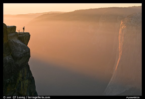 Hiker standing on top of sheer cliff at Taft point. Yosemite National Park (color)