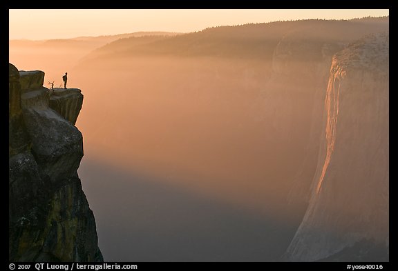 Hiker standing on top of sheer cliff at Taft point. Yosemite National Park, California, USA.