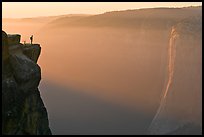 Hiker standing on top of sheer cliff at Taft point. Yosemite National Park ( color)