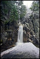 Snow-covered boulder and base of Chilnualna Falls. Yosemite National Park, California, USA.