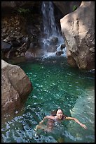 Girl swims in cool pool at the base of Wapama falls. Yosemite National Park, California, USA.