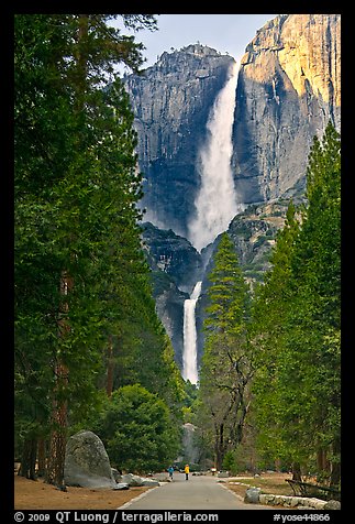 Tourists on path dwarfed by Upper and Lower Yosemite Falls. Yosemite National Park, California, USA.