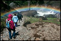 Hikers walking through rainbow, Mist Trail. Yosemite National Park, California, USA.