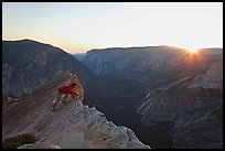 Hiker looking over the edge of the Diving Board, sunset. Yosemite National Park, California, USA. (color)