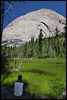 Hiker sitting at Lost Lake on west side Half-Dome. Yosemite National Park, California, USA.