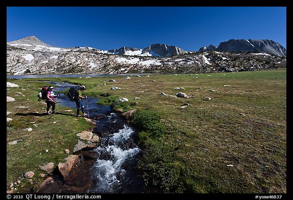 Backpackers crossing stream, Evelyn Lake. Yosemite National Park, California, USA.