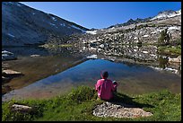 Hiker sitting by alpine lake, Vogelsang. Yosemite National Park, California, USA.