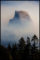 Half-Dome emerging from smoke at night. Yosemite National Park, California, USA.