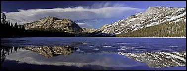 Mountains reflected in partly iced Tenaya Lake. Yosemite National Park, California, USA.