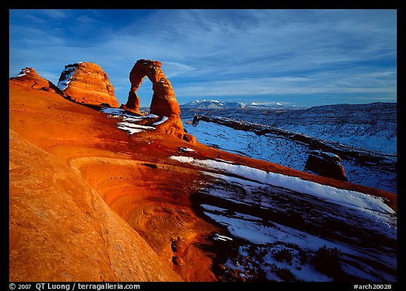 Sandstone bowl, Delicate Arch, and La Sal Mountains with snow, sunset. Arches National Park, Utah, USA.