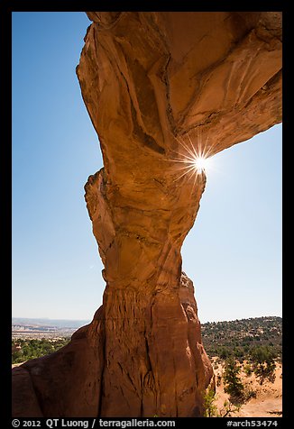 Sunburst at the crack of Broken Arch. Arches National Park, Utah, USA.