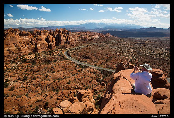 Tourist taking picture from top of fin. Arches National Park (color)