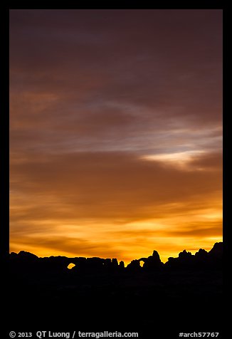 Windows and Turret Arch silhouetted against colorful clouds. Arches National Park (color)