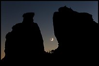 Crescent moon framed by Dollhouse spires. Canyonlands National Park, Utah, USA. (color)