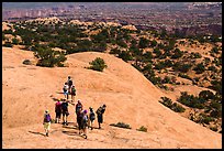 Hikers on Whale Rock. Canyonlands National Park, Utah, USA.