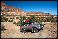 4WD vehicle driving over rocks in Teapot Canyon. Canyonlands National Park, Utah, USA.