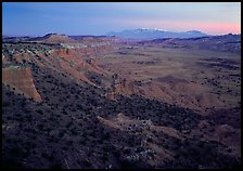 Cliffs, basin, and snowy mountains at dusk, Upper Desert, dusk. Capitol Reef National Park, Utah, USA.