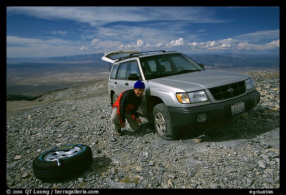 Man changing a flat tire on remote spot at top of Mt Washington. Great Basin National Park (color)