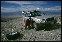 Man changing a flat tire on remote spot at top of Mt Washington. Great Basin National Park, Nevada, USA.