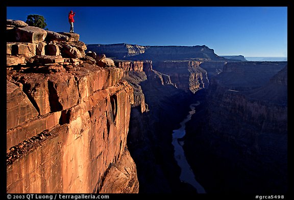 Hiker looking down into  Grand Canyon at Toroweap, early morning. Grand Canyon National Park, Arizona, USA.