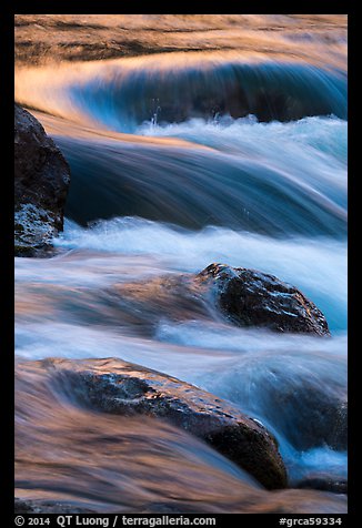 Boulders and rapids with warm light from canyon walls reflected. Grand Canyon National Park (color)