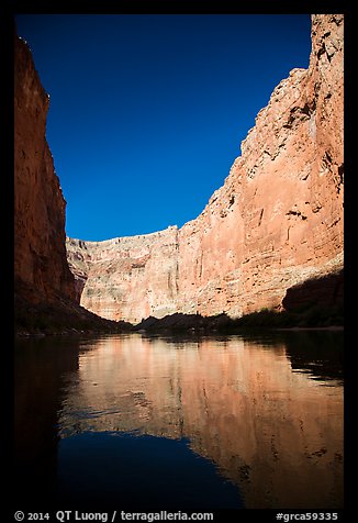 Steep limestone canyon walls reflected in Colorado River, early morning. Grand Canyon National Park, Arizona, USA.