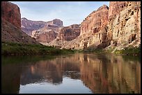 The Colorado river flows gently, framed by vividly layered canyon walls. Grand Canyon National Park ( color)