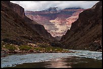 Mist clings to the upper cliffs as the river carves a dark path below. Grand Canyon National Park ( color)