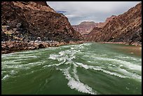 Whitewater churns through rapids framed by volcanic black schist and pastel cliffs. Grand Canyon National Park ( color)
