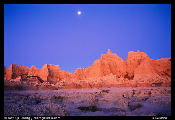 Moon and eroded badlands, Cedar Pass, dawn. Badlands National Park, South Dakota, USA.