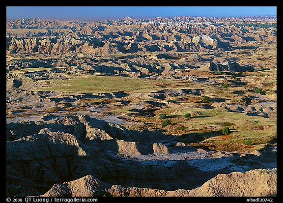 Prairie and eroded ridges stretching to horizon, early morning. Badlands National Park, South Dakota, USA.