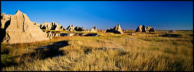 Badlands raising in tall grass prairie landscape, Cedar Pass. Badlands National Park, South Dakota, USA.