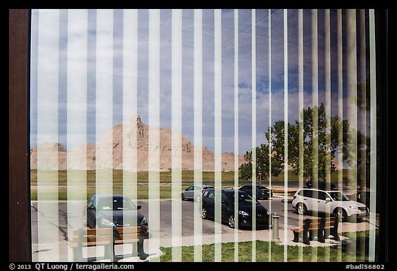 Badlands and parking lot, Visitor Center window reflexion. Badlands National Park, South Dakota, USA.