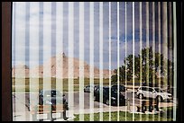 Badlands and parking lot, Visitor Center window reflexion. Badlands National Park, South Dakota, USA. (color)