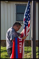 Native American ranger gathering US and Tribal flags. Badlands National Park ( color)