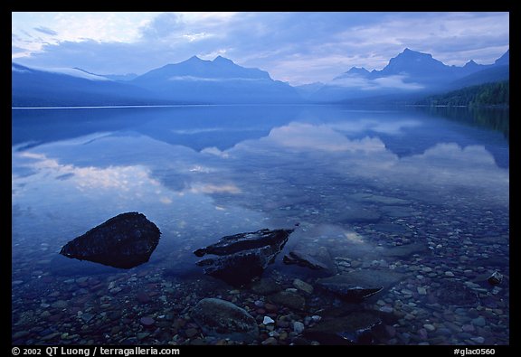 Rocks, peebles, and mountain reflections in lake McDonald. Glacier National Park, Montana, USA.